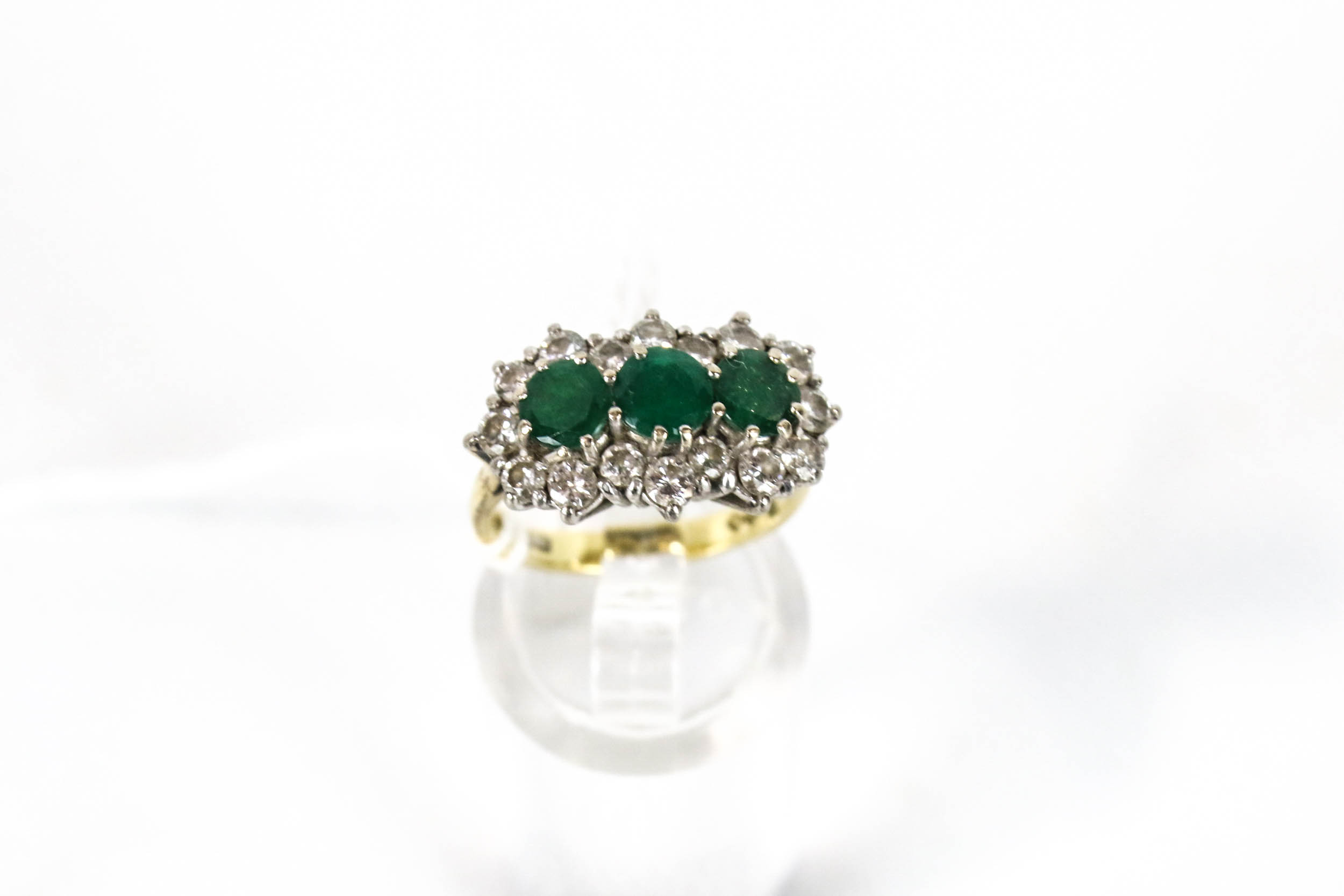A vintage gold emerald and diamond triple-cluster ring.