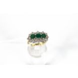 A vintage gold emerald and diamond triple-cluster ring.