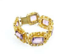 An early 20th century gold and amethyst six stone floral panel bracelet.