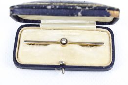 An early 20th century diamond single stone bar brooch. The old-cut stone circa 0.