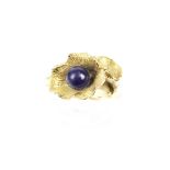 A flower ring set with a blue bead in unmarked yellow metal. The mount damaged, 4.