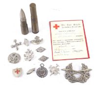 A collection of military related items. Including trench art bullets, cap badges, etc.