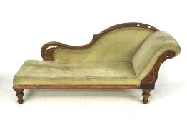 A vintage chaise lounge with green velvet upholstery.