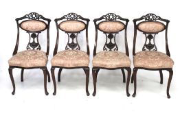 A set of four mahogany chairs with pink upholstered seats and backs.