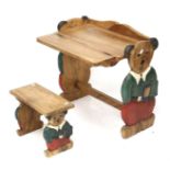 A child's nursery carved wooden desk and stool. With carved teddy bear supports.