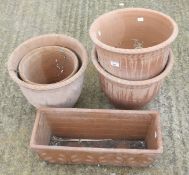Four large terracotta plant pots and a trough.