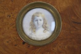 An Edwardian tondo miniature portrait painting. A watercolour on ivory portrait of a young girl.