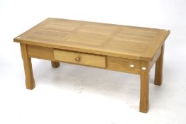 A contemporary light oak coffee table.