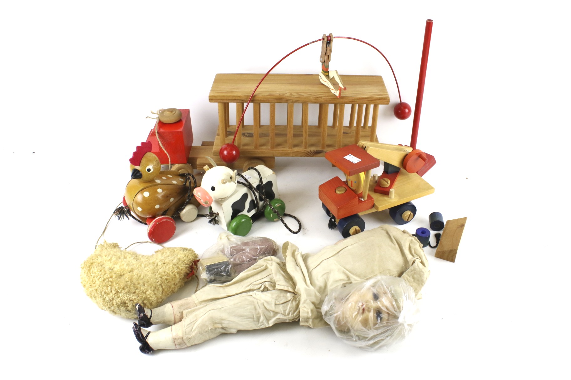 An assortment of vintage toys. Including a wooden pull along train, a wax head doll, etc. Max.