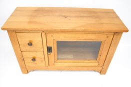 A contemporary oak TV cabinet with a lazy susan top.