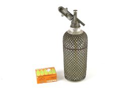 A vintage glass Sparklets soda syphon with wire mesh covering. No. 265 on the base, H34cm.