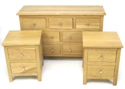 A contemporary light oak chest of drawers and a pair of bedside cabinets.