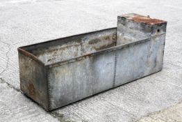 A galvanised metal riveted water trough.