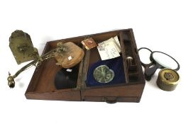 A wooden box (previously a writing slope) containing an assortment of collectables.