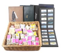 A large collection of cigarette and collectors cards in a wicker basket.