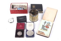 A collection of assorted coins, a pocket watch and an autograph book.