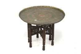 An Eastern brass tray top table.