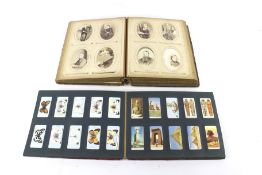 A Victorian photograph album and a collection of cigarette cards.