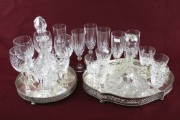 Two glass decanters, two silver plated trays and two sets of six glasses.