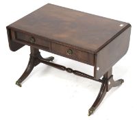 A Regency style drop leaf side table. With two drawers, brass claw feet and turned stretcher.