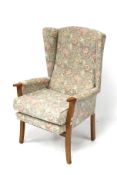 A contemporary wingback armchair. With floral decorated upholstery.