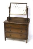 A 20th century oak chest of drawers and a dressing mirror.