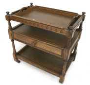 An Adam Bede oak tone drawer tea trolley. With removable tray, on original casters, H72.