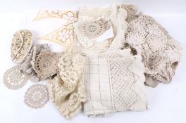 An assortment of lace and textiles. Including doilies, place mats, a beaded purse etc.