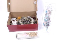 An assortment of costume jewellery. Including pendants, brooches, a pearl necklace, etc.