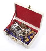 An assortment of costume jewellery. Including wooden beads, bangles, brooches, etc.