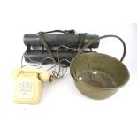 A preserve pan, vintage telephone and military carrier.