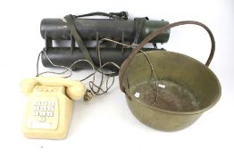 A preserve pan, vintage telephone and military carrier.