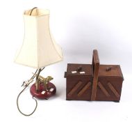 A vintage folding sewing work box and a table lamp.