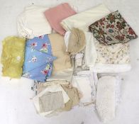 An assortment of textiles. Including embroidered tablecloths, crochet doilies, a quilt, etc.