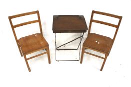 A vintage wooden childs desk and two chairs.