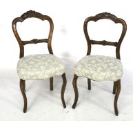 A pair of oak balloon back dining chairs.