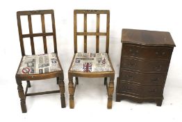 A pair of vintage chairs and a reproduction chest of drawers.