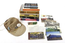 An assortment of train books and collectables. Including a hat with badges and postcards, etc.