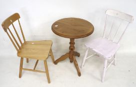 A contemporary pine circular table and two chairs.