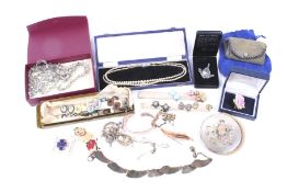 An assortment of costume jewellery. Including pairs of earrings, compact, etc.