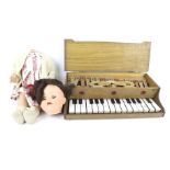 A vintage walking doll and a toy piano.