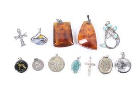 Twelve silver and white metal pendants. Including examples set with amber, turquoise, a locket, etc.