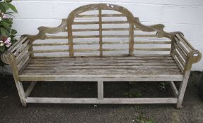 An lutyens style wooden garden bench.
