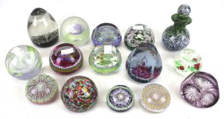 A collection of Perthshire and other caned glass paperweights and a small scent bottle.