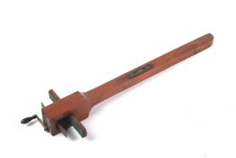 A mahogany measuring device with spirit level to the body and crank handle to one end.