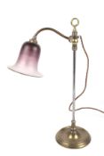 A mid-century brass desk lamp with graduated aubergine glass fluted shade.