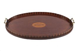 An Edwardian mahogany inlaid oval tray with conch shell motif to the centre.