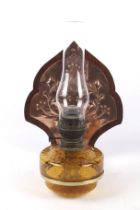 A late 19th century wall bracket with an amber glass Matador oil lamp.