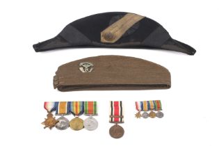 Two military hats and a group of medals.