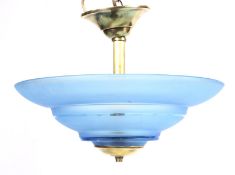 An Art Deco style frosted blue glass and brass circular stepped ceiling light.